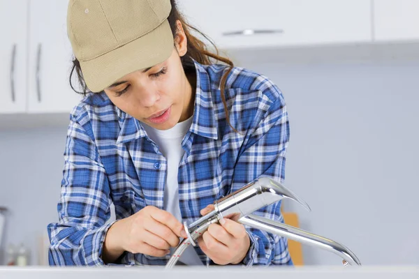 Vrouw loodgieter tot vaststelling van een gootsteen — Stockfoto