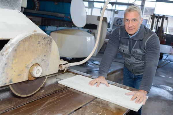 Portrait d'un travailleur âgé utilisant une scie à banc — Photo