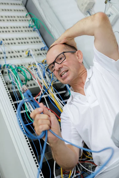 Homem frustrado segurando cabos — Fotografia de Stock