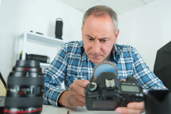Fotógrafo verificando lente da câmera — Fotografia de Stock
