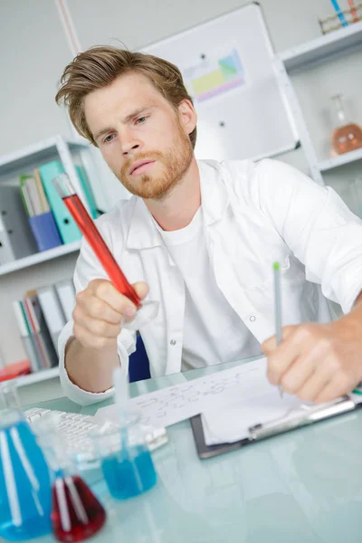 Chemist observing the chemical — стоковое фото