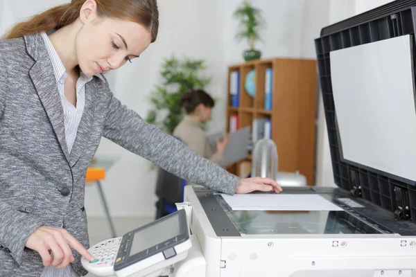 Belle fille d'exploitation copieur dans le bureau moderne — Photo