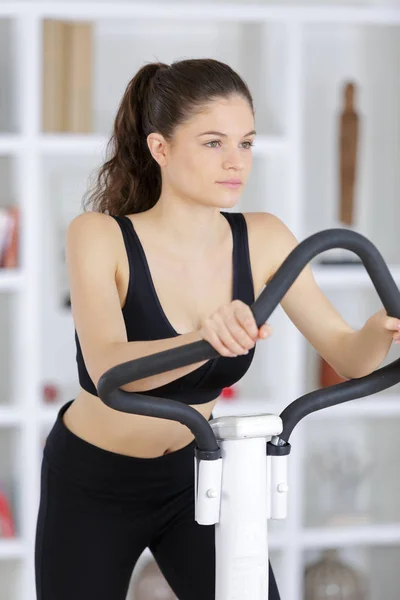 Giovane signora utilizzando attrezzature per il fitness — Foto Stock