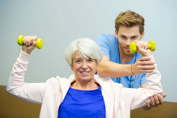 Agradable senior mujer de entrenamiento fuera con mancuernas —  Fotos de Stock