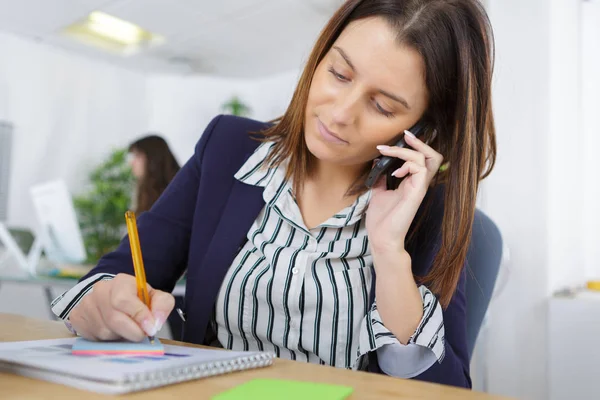 Mujer joven con teléfono y portátil — Foto de Stock