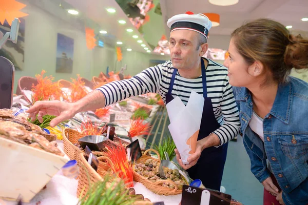 Pescadero que asiste cutomer y pescado — Foto de Stock