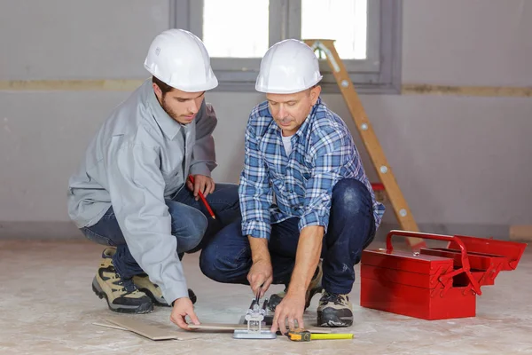 Arbetstagare som förbereder nivån för betongplatta — Stockfoto