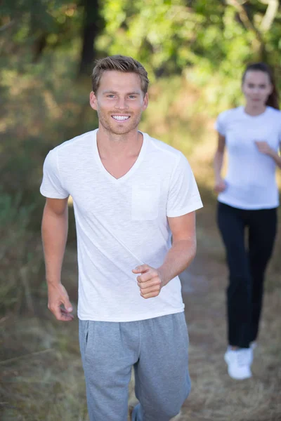 Ungt par kör i tidiga morgonen på park — Stockfoto