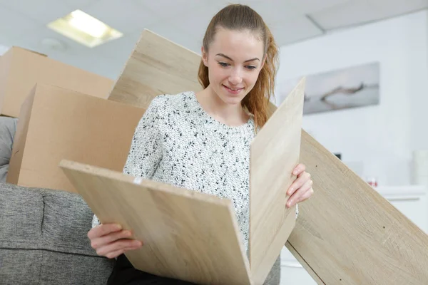 Femme heureuse s'amuser à assembler des meubles à la nouvelle maison — Photo