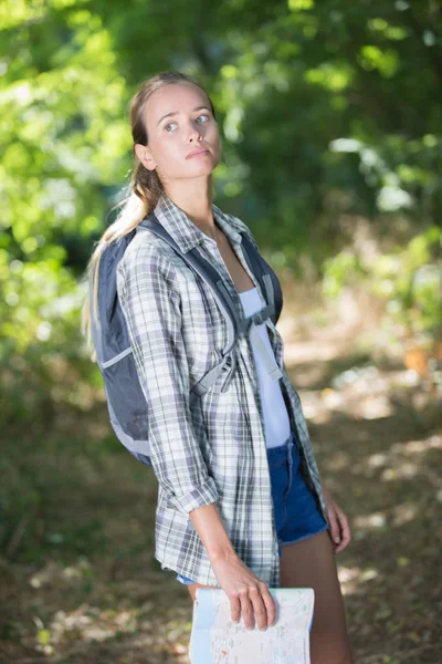 Bela mulher com uma mochila perdida na floresta noturna — Fotografia de Stock