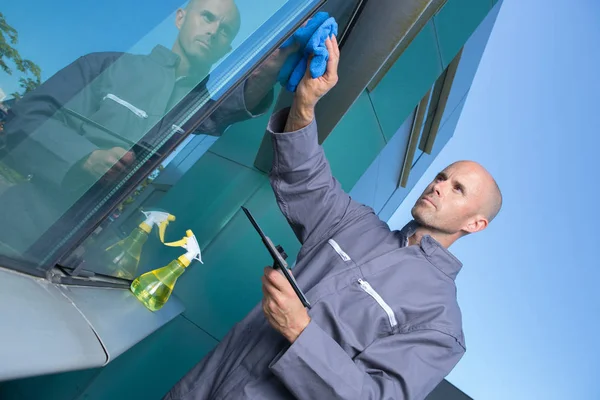 Manliga arbetstagare rengöring glas — Stockfoto