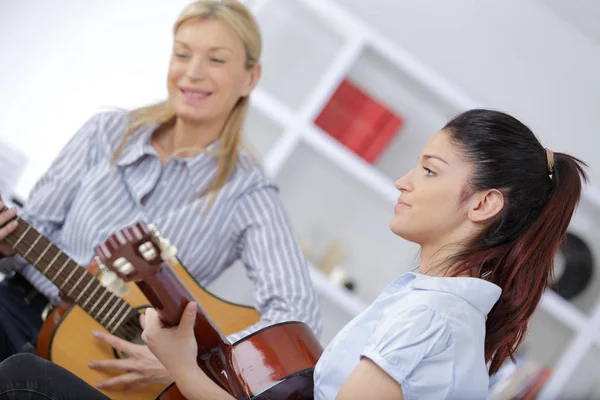 Moeder en dochter samen gitaar spelen — Stockfoto