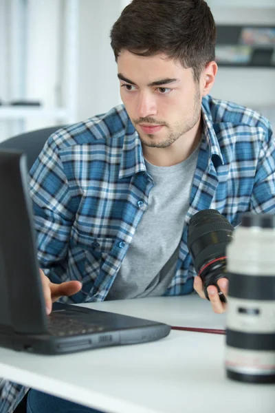 Photographer checking his digital pictures on laptop in agency — Stock Photo, Image