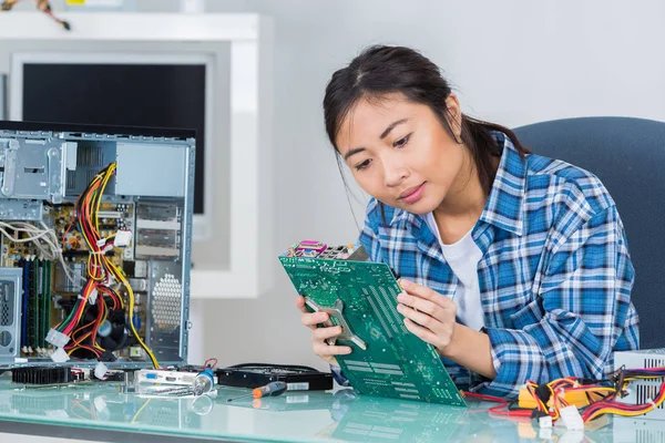 Jonge vrouw tot vaststelling van de systeemkaart van een computer — Stockfoto