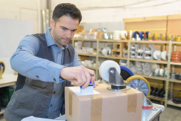 Warehouse worker preparing a shipment in a large warehouse — Stock Photo, Image