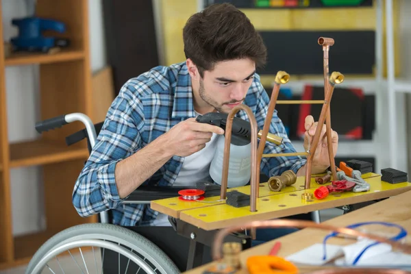 Unga rörmokaren arbetare i rullstol — Stockfoto