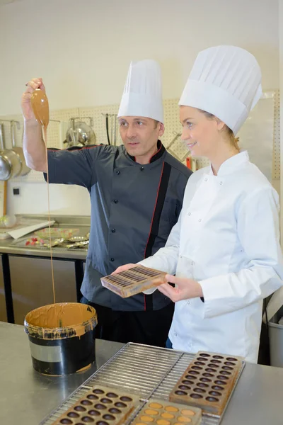 Chocolate chef and assistant by industrial chocolate mixer — Stock Photo, Image