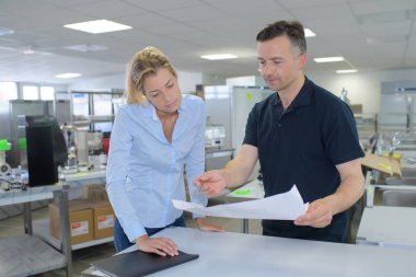 staff discuss warehouse logistics in an on-site office clipart