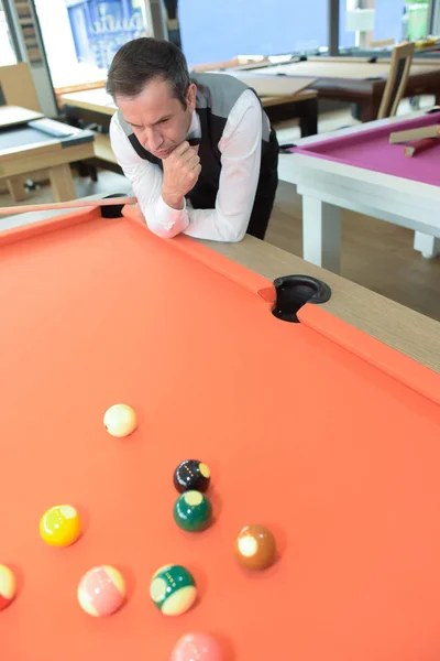 Homem joga na mesa de bilhar piscina — Fotografia de Stock