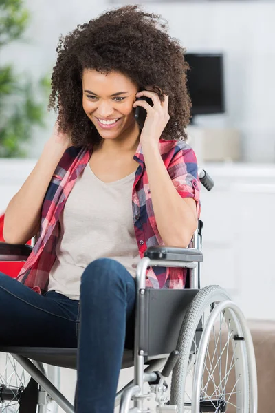 Handikappad kvinna i rullstol på mobiltelefon — Stockfoto