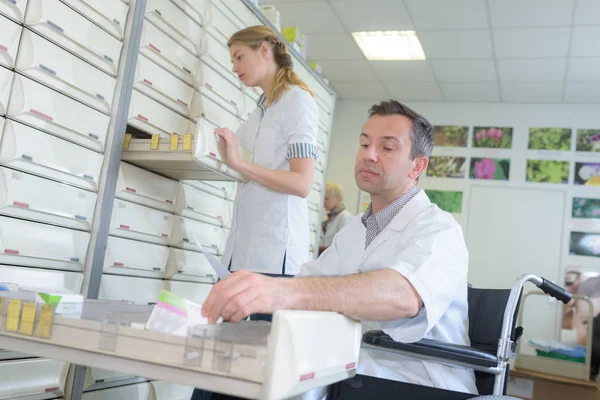 Pharmaceutical chemist opening drawer for drugs storage in farmacy — Stock Photo, Image