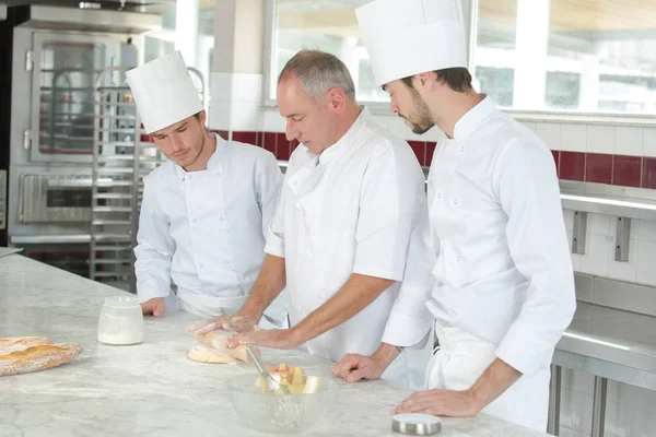 Kulinářské studenti učí, jak míchat těsto v kuchyni — Stock fotografie