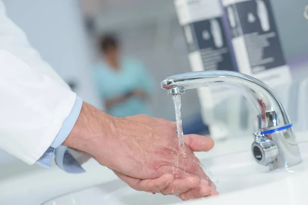 Wassen van de handen in een gootsteen ziekenhuis arts — Stockfoto