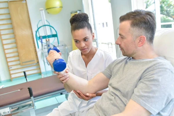 Mann mittleren Alters im Fitnessstudio macht Fitnessübungen mit Hanteln — Stockfoto