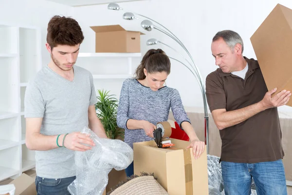 Casal se movendo em uma nova casa e fechando caixas de papelão — Fotografia de Stock