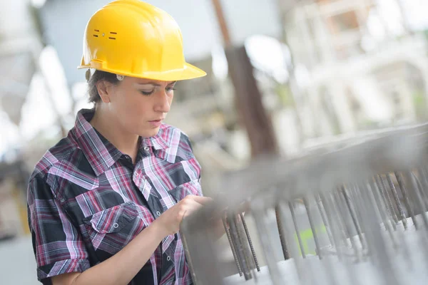 Kvinna arbetare med hjälm över vita i fabrik — Stockfoto