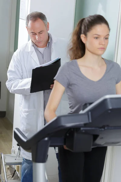 Paciente que utiliza cinta de correr en el departamento de fisioterapia del hospital — Foto de Stock