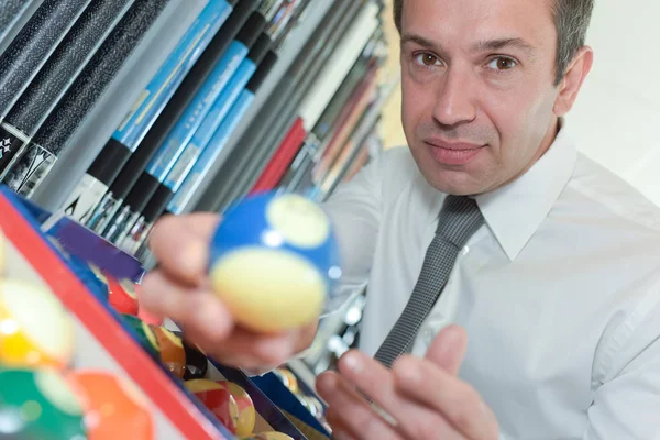 Homem segurando uma bola de bilhar — Fotografia de Stock