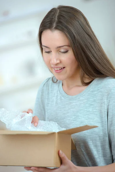 Trevlig kvinna öppnar en låda — Stockfoto