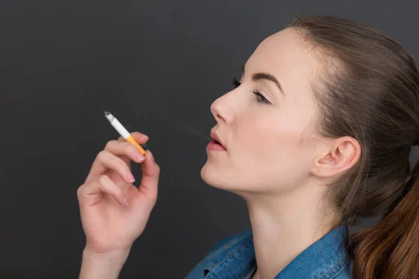 Beautiful young woman enjoying her cigarette — Stock Photo, Image