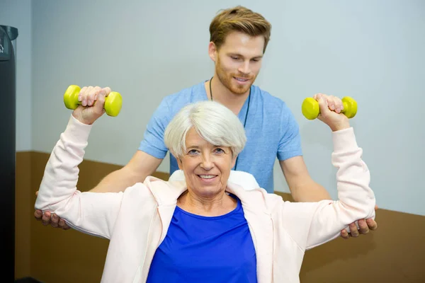 Äldre kvinna arbetar med sjukgymnast — Stockfoto