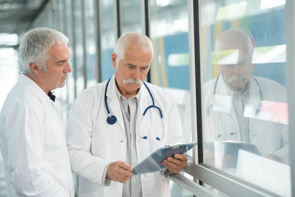 Two doctors at hospital with clipboard — Stock Photo, Image