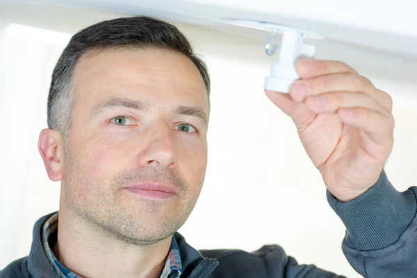 Handsome electrician changing a light bulp — Stock Photo, Image