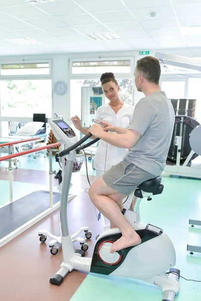 Patient som har sjukgymnastik på motionscykel på sjukhus — Stockfoto