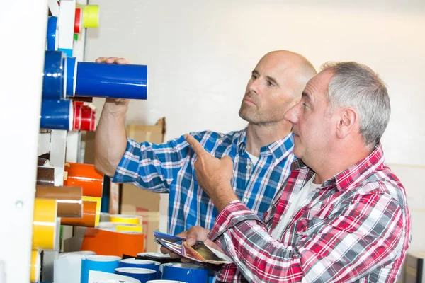 Arbeiter diskutieren Papierrollen von Druckern — Stockfoto