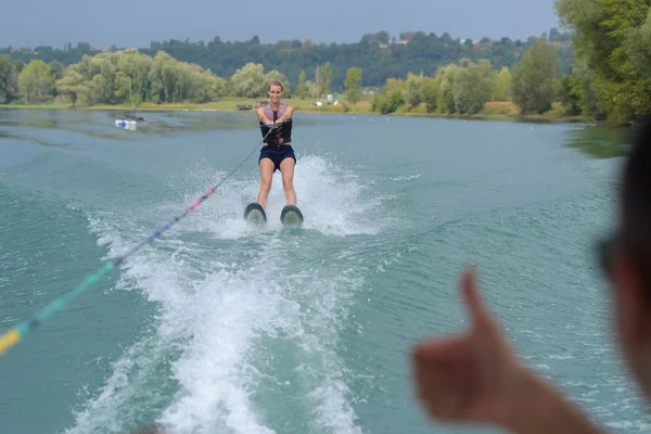 Mulher jovem wakeboarding e água — Fotografia de Stock