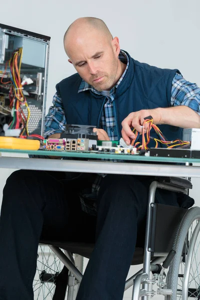 Travailleur handicapé en fauteuil roulant réparer un ordinateur — Photo