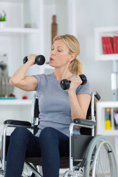 Heureux handicapé sur un fauteuil roulant avec un haltère — Photo