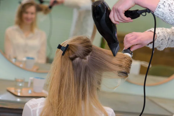 Woman at hairdresser having a hairbrush — Stock Photo, Image