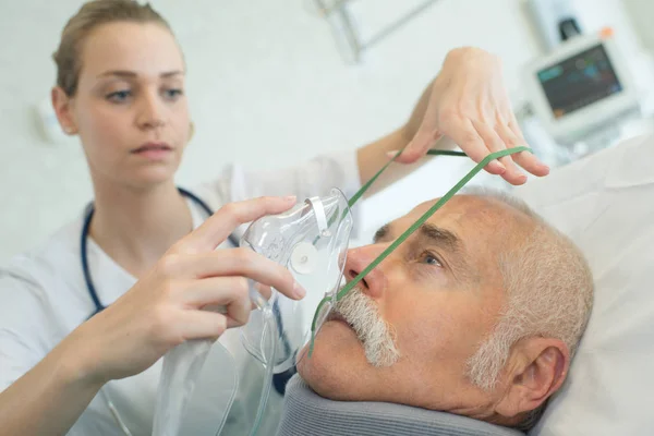 Arzt setzt Sauerstoffmaske auf Seniorin — Stockfoto