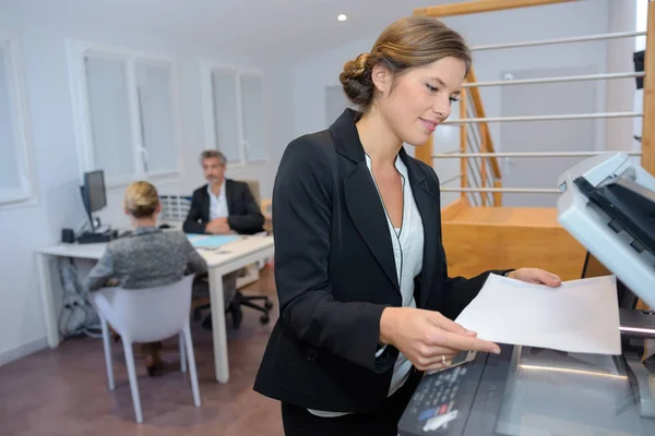 Tânără femeie de afaceri care utilizează o mașină de fotocopiat în birou — Fotografie, imagine de stoc