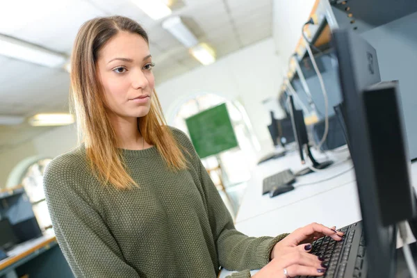 Jolie étudiante regardant un écran d'ordinateur de bureau — Photo