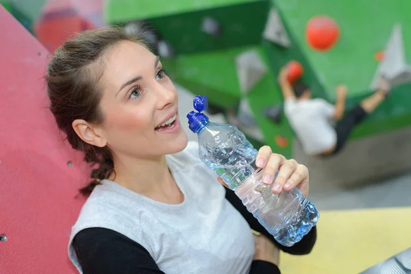 Chica beber agua en interior centro de escalada — Foto de Stock