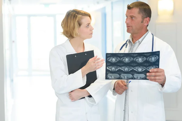 Два врача говорят и женщина — стоковое фото
