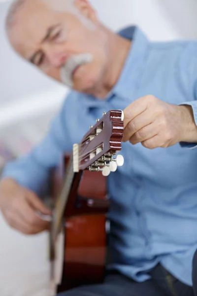 Homem aposentado afinação guitarra clássica — Fotografia de Stock
