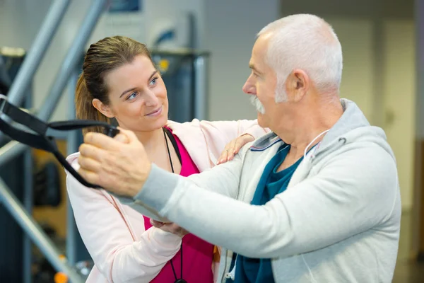 Hombre mayor en una discusión con un instructor de gimnasio — Foto de Stock